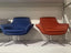Steelcase BOB Chairs Two chairs, one blue and one red, on a white shelf.
